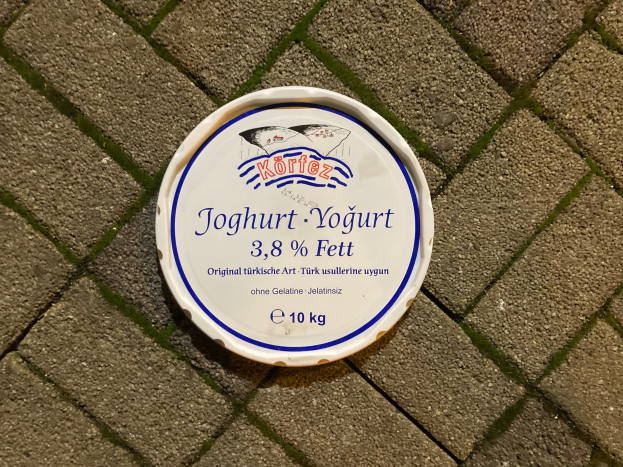 Ein Teller Joghurt mit Text darauf, der auf einem Ziegelweg steht.