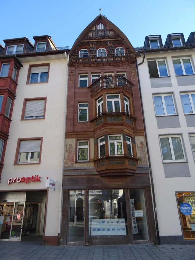 Gewerbliches Eigentum zum Verkauf in Heidelberg, Deutschland, mit einem mehrfenstrigen Gebäude an einer Straße mit einem klaren blauen Himmel im Hintergrund.