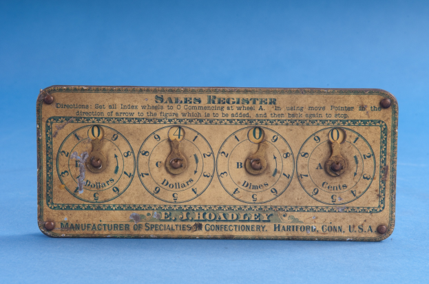 Ein altmodisches Verkaufsregister mit Text und Zahlen auf einem blauen Hintergrund, das wahrscheinlich das Datum und die Uhrzeit anzeigt.