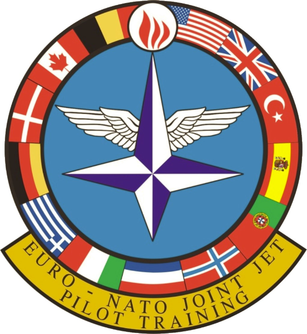 Logo der NATO Joint Jet Pilot Training mit einem blauen Kreis mit einem weißen Stern in der Mitte, umgeben von vier Fahnen in verschiedenen Farben und der weißen Aufschrift "NATO Joint Jet".