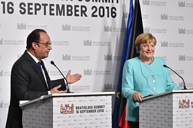 Bundeskanzlerin Angela Merkel und Frankreichs Präsident François Hollande stehen an Rednerpulten mit Mikrofonen, sie lächeln, mit einem 'Bratislava-Gipfel 2016'-Schild dahinter.