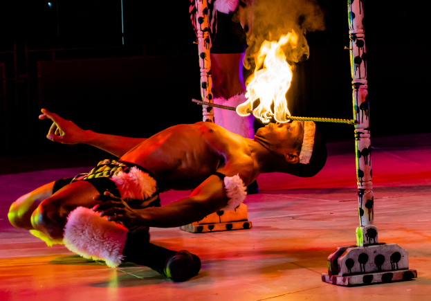 Eine Person schaut auf ein Feuer auf einer Stange.