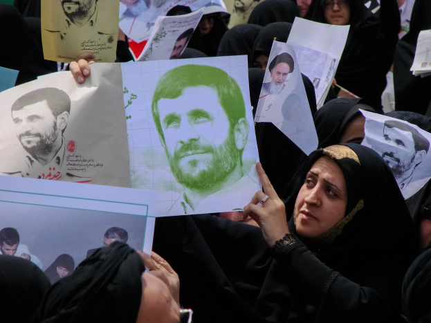 Gruppe iranischer Frauen in schwarzer Kleidung hält Fotos von Präsident Mahmoud Ahmadinejad während einer Kundgebung in Tehran hoch.