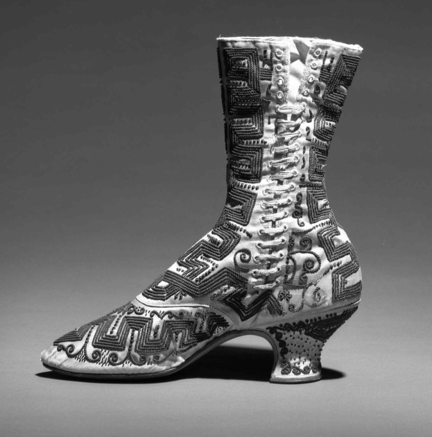 Ein Paar hochhackige Stiefel mit farbenfroher, detallierter Stickerei in Blautönen, Grüntönen und Gelb.