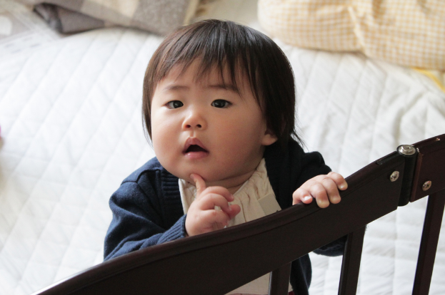 Ein Kind neben einem Bett.