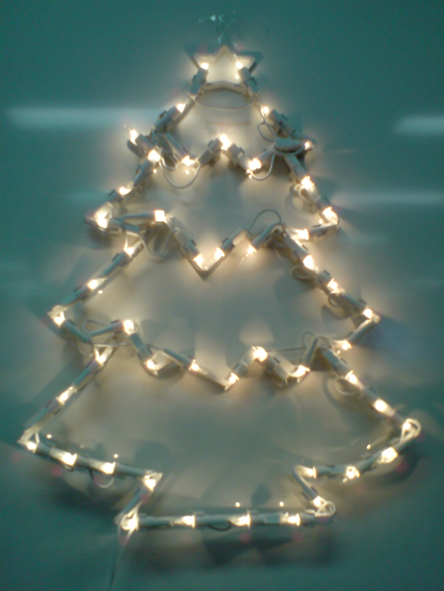 Eine Weihnachtsbaumstruktur mit Lichtern, die an einer Wand angebracht ist.