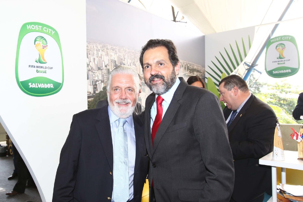 Eine Gruppe von Menschen steht mit einigen, die lächeln, im Hintergrund ein FIFA-WM-Poster.