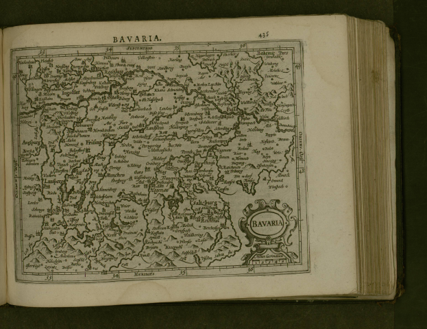 Ein aufgeschlagenes Buch mit einer detaillierten Karte von Bayern, auf der Städte und Ortschaften beschriftet sind, begleitet von beschreibendem Text.
