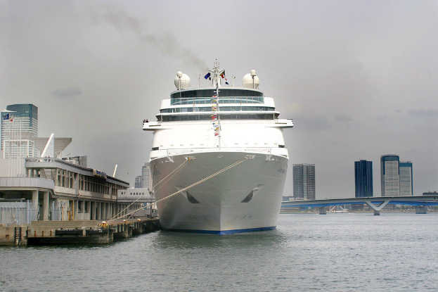 Ein Schiff schwimmt auf dem Wasser neben einer Br├╝cke und zahlreichen Geb├Ąuden.