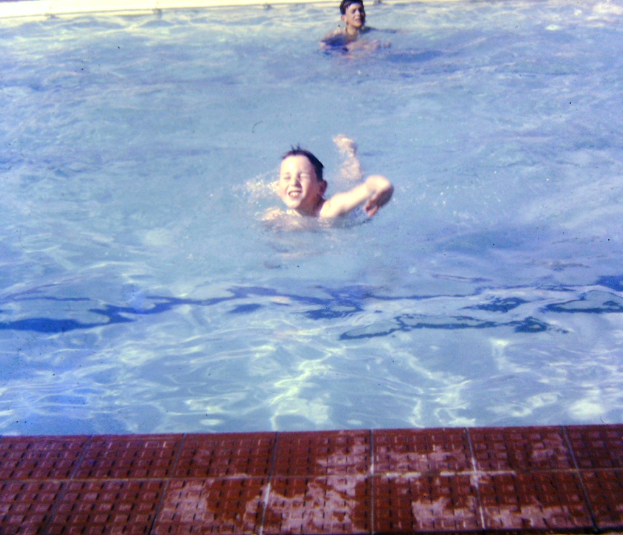 Zwei Kinder beim Schwimmen in einem Wasser gefüllten Pool.