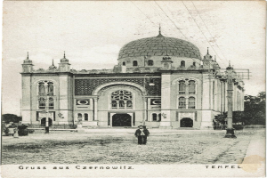 Ein altes Schwarz-Weiß-Foto der Tempelkirche in Czernowitz, Deutschland, umgeben von Menschen, Pfählen, Bäumen und Drähten, mit Text unten.