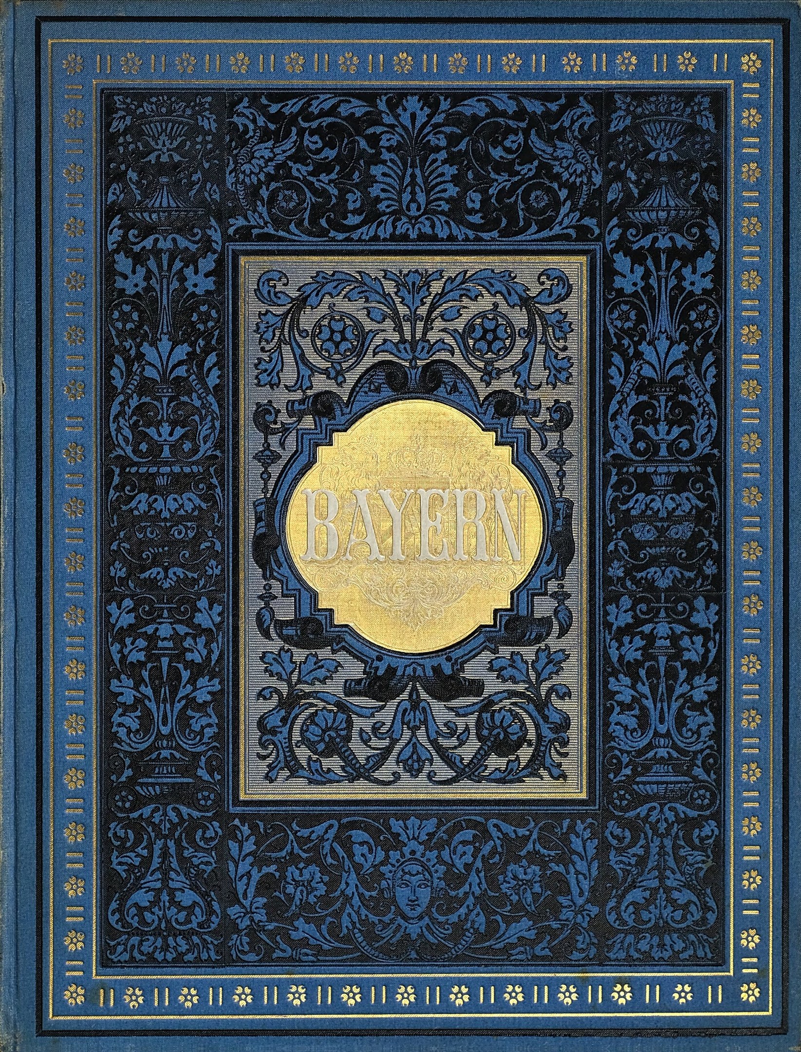 Ein blau-goldenes Buch mit dem Wort 'Bayern' auf dem Cover, das mit kunstvollen Verzierungen geschmückt ist.
