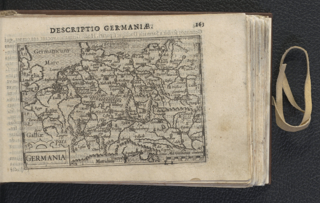 Offenes Buch mit einer Deutschlandkarte und begleitendem Text auf einer schwarzen Oberfläche.