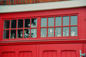 Eine rote Feuerwache mit roter Tür und Glasfenstern, die Trophäen zeigen.