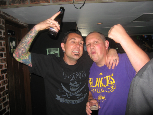 Eine Gruppe von Menschen mit einem Mann, der ein Bier auf der linken Seite hält.