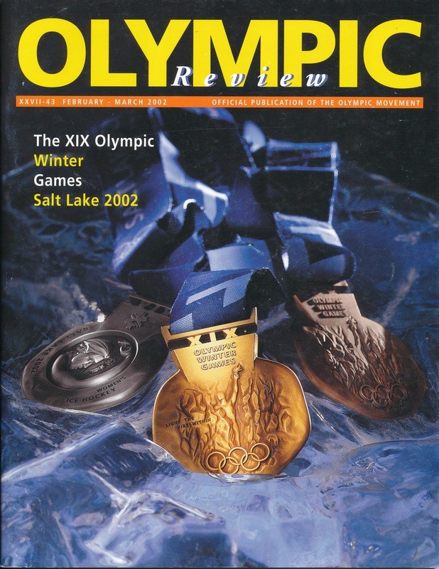 Olympische-Revue-Magazin-Cover mit mehreren Medaillen in verschiedenen Größen und Farben und fetter Schrift.