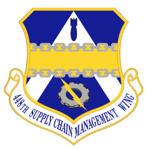 Logo des 48. Versorgungsgeschwader mit einem blauen Schild mit einem weißen Stern und einem weißen Banner mit der Aufschrift "Versorgungsgeschwader" in blau, alles von einem weißen Rand mit schwarzem Text umgeben.