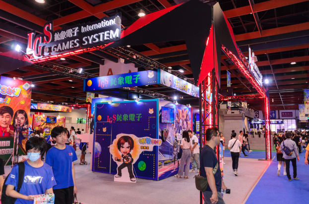 Eine Gruppe von Menschen geht durch einen Convention-Saal mit Ständen, trägt Taschen und hält Gegenstände, mit vielen anderen im Hintergrund auf einer Gaming-Messe in China.