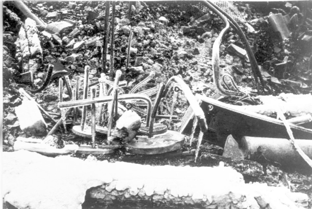 Ein Schwarz-Weiß-Foto eines Schutthaufens, einschließlich Metallobjekten und Rohren, wahrscheinlich Überreste der Tschernobyl-Katastrophe.