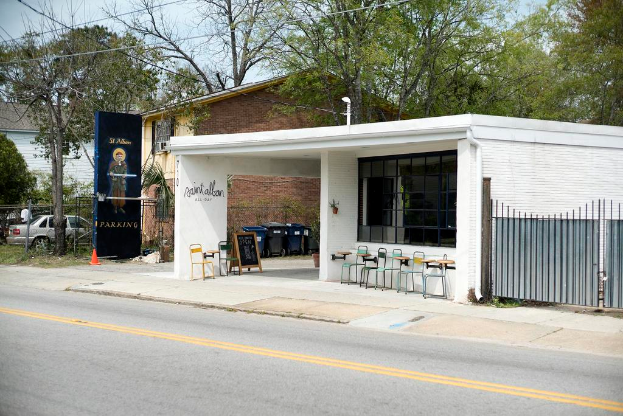 Ein Restaurantgebäude neben einer Straße gelegen, mit Bäumen im Hintergrund.