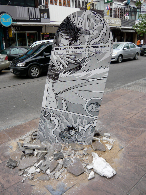 Ein Brett auf einem Gehweg mit Autos auf der benachbarten Straße neben einem Gebäude.