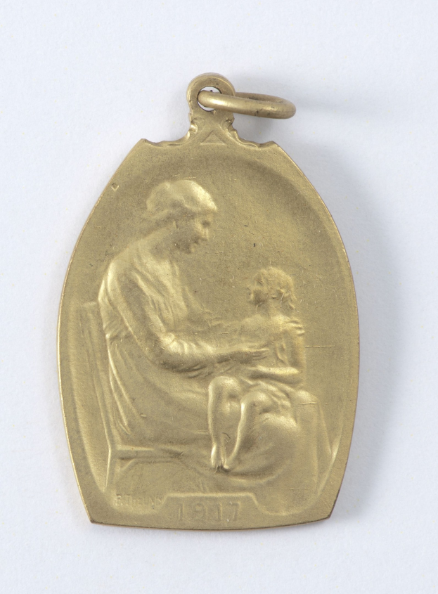 Goldmedaille mit Relief einer Frau in weißem Kleid mit Haarknoten, die ein Kind hält, das zu ihr aufschaut, beide mit "Mutter und Kind" beschriftet
