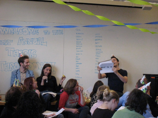 Eine Gruppe von Menschen feiert ihren ersten jährlichen Thesistreff, mit Bändern auf dem Dach und einigen Personen mit Kappen.