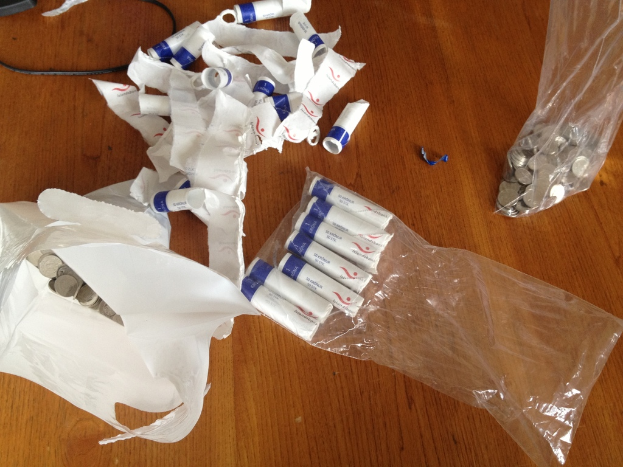 Weiße Objekte und Münzen auf einer hölzernen Oberfläche.