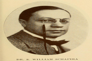 Ein Schwarz-Weiß- Foto von Dr. S. William Schapira in einem Blazer und mit Brille, mit Text unten.