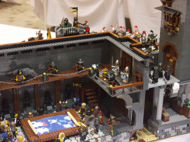 Eine Lego-Königreichszene mit Soldaten, Offizieren und einer Kartenskizze auf einem Tisch, mit einem weißen Tuch im Hintergrund.