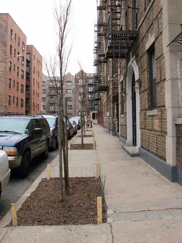 Eine spärlich besiedelte Stadtlandschaft mit wenigen Autos und Gebäuden in der rechten Ecke und einigen anderen Gebäuden in der linken Ecke.